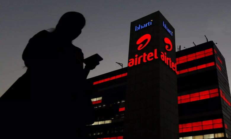 file photo a girl checks her mobile phone as she walks past the bharti airtel office building in gurugram