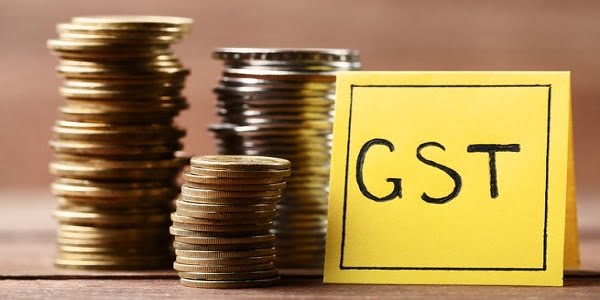 inscription gst on paper with stack of coins