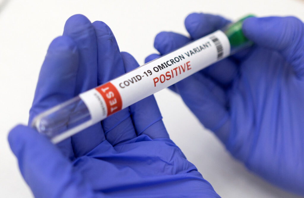illustration shows test tube labelled covid 19 omicron variant test positive