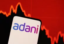 illustration shows adani logo decreasing stock graph